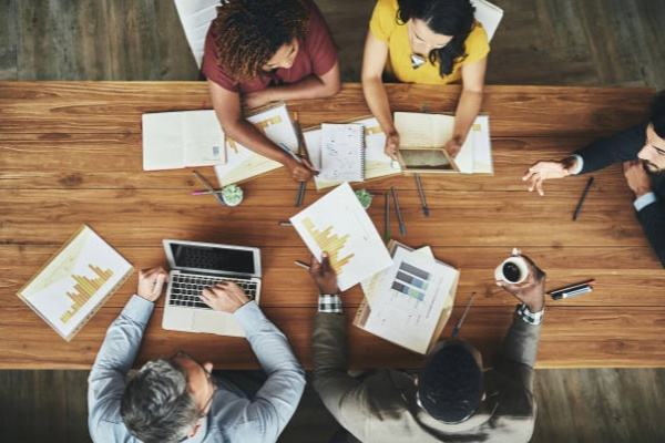 Birds-eye view of business High angle shot of a team of businesspeople meeting around the boardroom table in the office Enterprise cooperation stock pictures, royalty-free photos & images